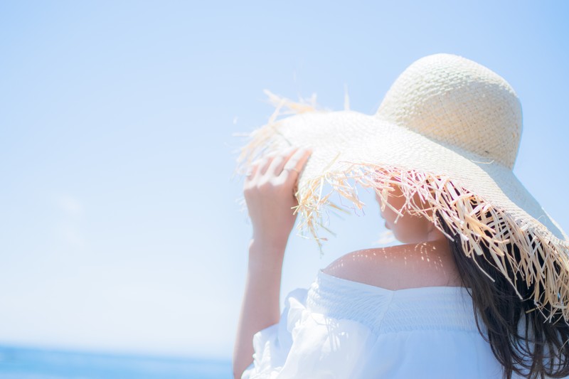 シュノーケリングセットと浮き輪を持って、海に駆け出すこんがり焼けた女の子